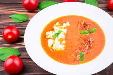 tomato soup, on a wooden background