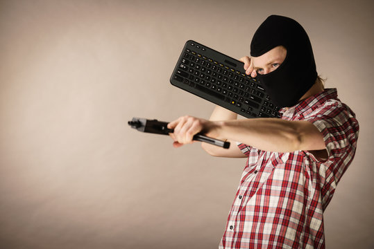 Man in balaclava holding keyboard and gun