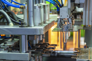 The  preform shape in the heater for plastic bottles manufacturing process at the drinking factory. Drinking water manufacturing process.