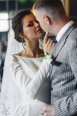 Kissing newlyweds have fun posing in the room