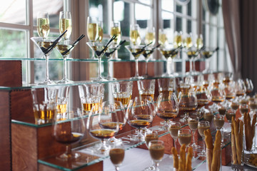 Glasses with different alcohol coktails and beverages stand on the table