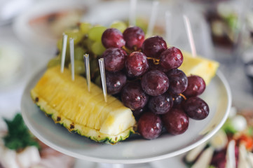 Pineapple and grape served on white plate