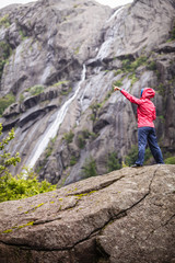 Naklejka premium Woman on mountain rock enjoying beautiful view