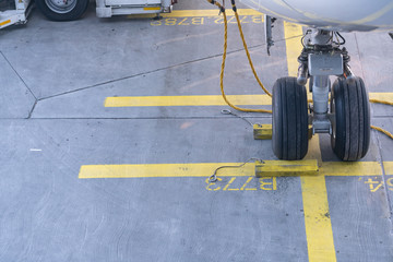  Landing Gear of a modern airliner - tires of a plane - close up shot.
Wheels of airplane with aircraft chocks and chains on the landing field.