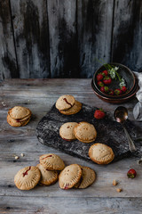 high angle view of tasty cookies with strawberries on wooden table