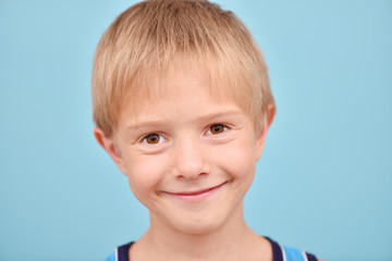 A boy on a blue background. Isolated portrait of a teenager.
