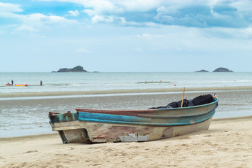 Fototapeta na wymiar Wooden boat on the sand The seaside at Suan Pradipat in Prachuap Khiri Khan , Thailand.