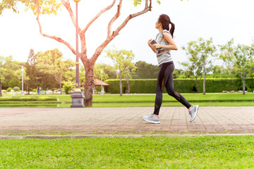 Unidentified woman jogging in the park with in summer.