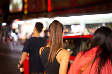 Woman tourist looking for taxi at night time.