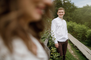 Fototapeta premium Happy pregnant family having fun time in summer nature. 