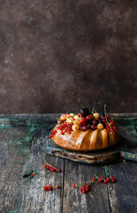 appetizing cake with strawberries and currants on wooden table