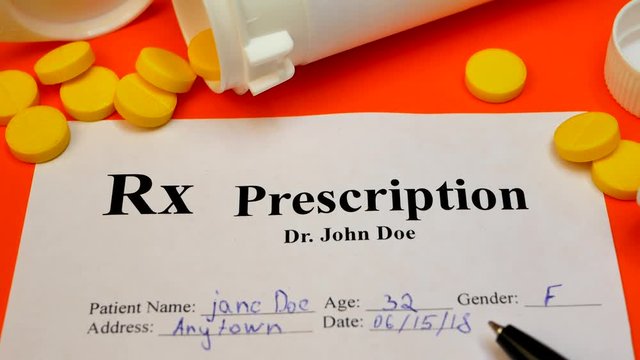 Prescription for tablet pills or drugs on orange background with bottle and yellow tablets or pills