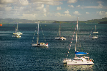 Luxury yachts anchored in the blue water with fort on background