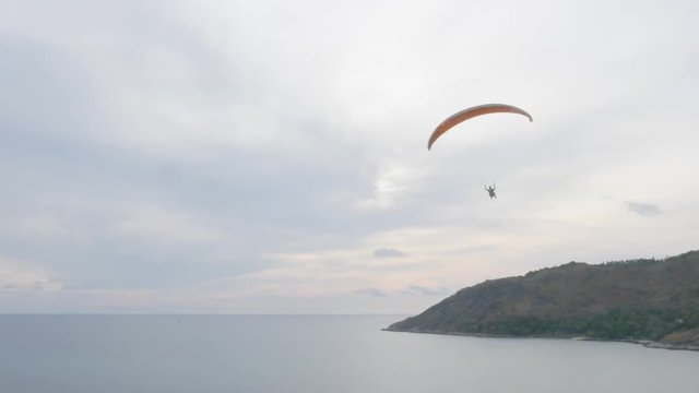 Paragliding over beautiful cape at sunset.