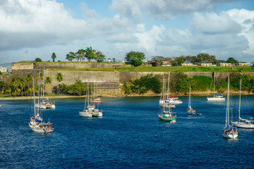 Fototapeta na wymiar Luxury yachts anchored in the blue water with fort on background