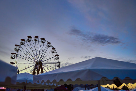  merry-go-round, carousel Ferris wheel by the sea, among beach umbrellas
