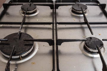 Dirty gas stove burners in kitchen room close-up