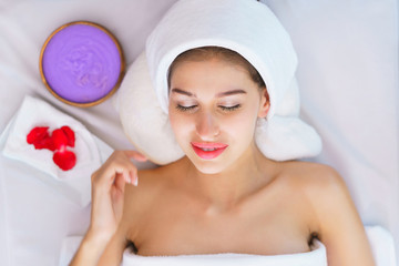 Top view of Young beautiful woman lying on the bed with happy spa body and scrub skin at spa salon. concept of relaxing health aroma spa, treatment and body massage.