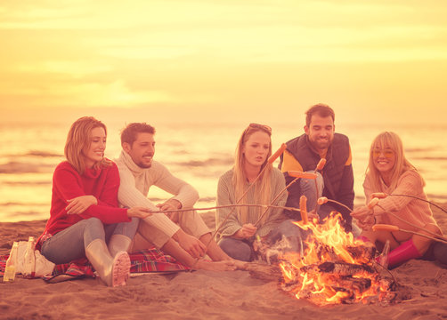 Group Of Young Friends Sitting By The Fire at beach