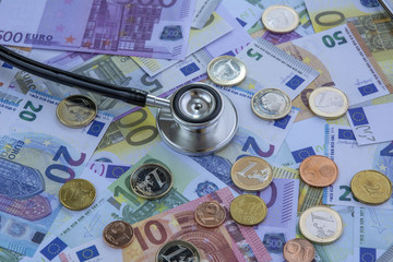 Coste de la medicina: estetoscopio sobre una pila de euros