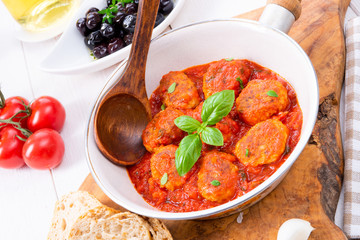Baked mini meatballs in tomato sauce with basil
