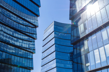 Glass facade of the buildings with a blue sky.