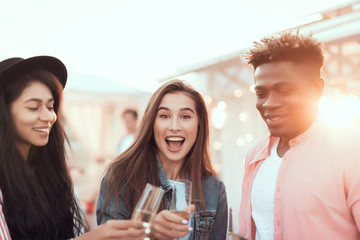 Portrait of positive girls and laughing man tasting alcohol beverage