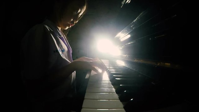 Asian little girl practicing piano