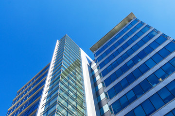 Glass facade of the building with a blue sky.
