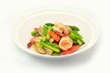 Stir fried asparagus with shrimp on white plate and white background.
