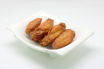Deep fried chicken wing with fish sauce on white plate and white background.