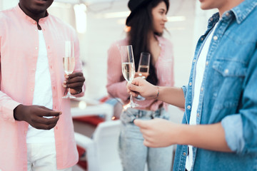 Two male and outgoing lady tasting glasses of delicious champagne while communicating during party