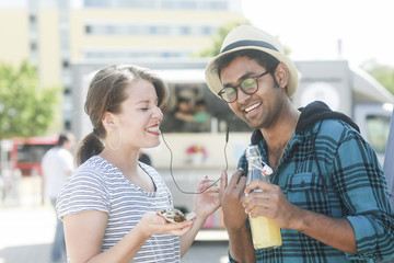 Junges Paar feiernd mit Sektgläsern und bluetooth Ohrstecker