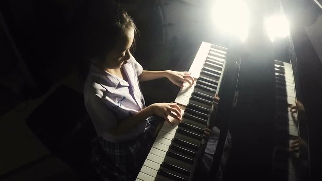 Asian little girl practicing piano