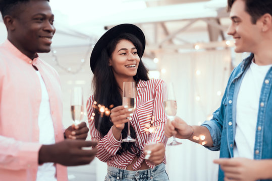 Cheerful woman speaking with cheerful friends while enjoying appetizing alcohol liquid