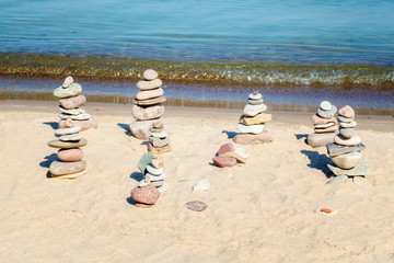 Pyramids of balanced stones on the beach near the sea