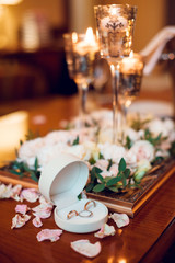 Beautiful wedding composition of white flowers and wedding rings on the wooden table. Wedding concept