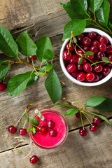 Cherry milkshake or smoothie on a dark wooden table. Healthy juicy vitamin drink diet or vegan food concept. Top view flat lay background.