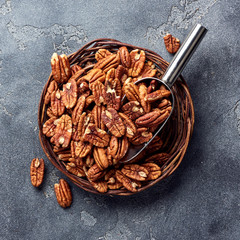 Pecan nuts and scoop on gray table