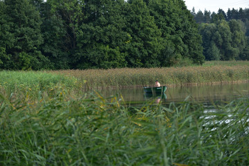 Fototapeta na wymiar wędkarz siedzący w łódzce na jeziorze
