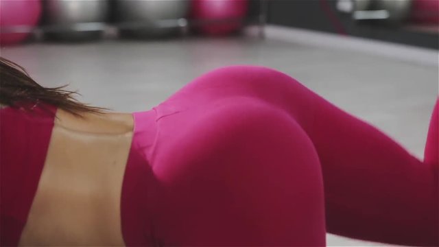 Muscles of a fit woman exercising kickbacks at gym