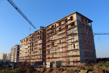 Large construction site including several cranes working on a building complex
