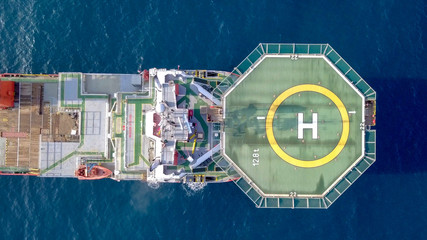 Aerial footage of a Medium size red Offshore supply ship with a Helipad and a large crane © STOCKSTUDIO