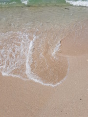 blue clear water and white sand on a sunny day