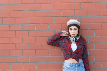 Portrait asian hipster girl on brick wall background,Hippie dress style,Thailand modern woman lifestyle,Beauty fashion portrait outdoor