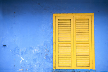 Gelbe Fensterläden an blauem Wohnhaus