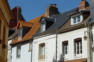 Fototapeta na wymiar Windows, chimneys and roofs of old residential houses in Normandy, France. Old town architecture, beautiful facades, typical french houses. Background