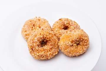 Small sweet donuts on white plate and white background with room for text