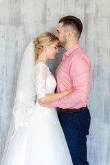 Happy wedding couple hugging and kissing. Beautiful young bride and groom, just married. Couple in love. Shallow focus and some noise.