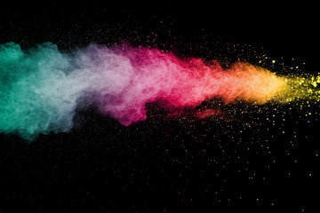 Explosion of color powder on black background. Splash of color powder dust on dark background.